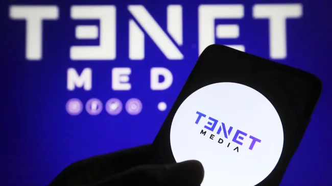In this photo illustration, a Tenet Media logo is seen on a smartphone and on a pc screen.